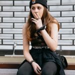 teenage girl smoking cigarette on street